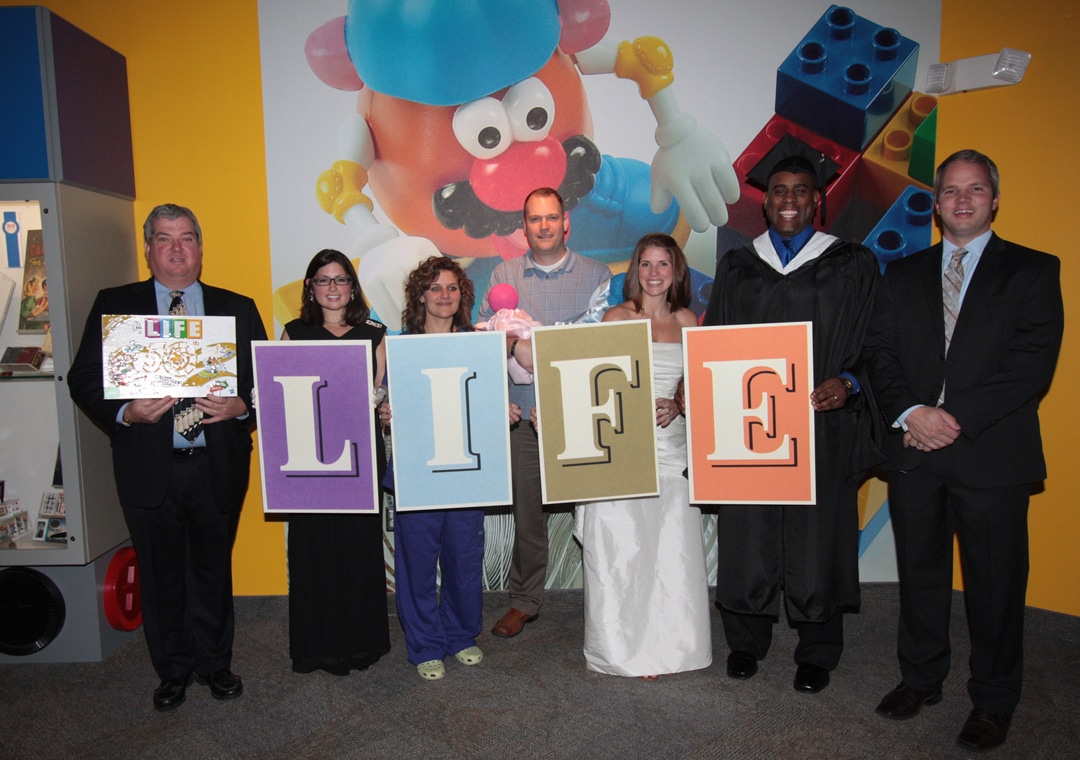 Characters representing landmark moments in The Game of Life pose with Hasbro Games representatives George Burtch (left) and Jay Bruns at the National Toy Hall of Fame at the Strong, November 2010.