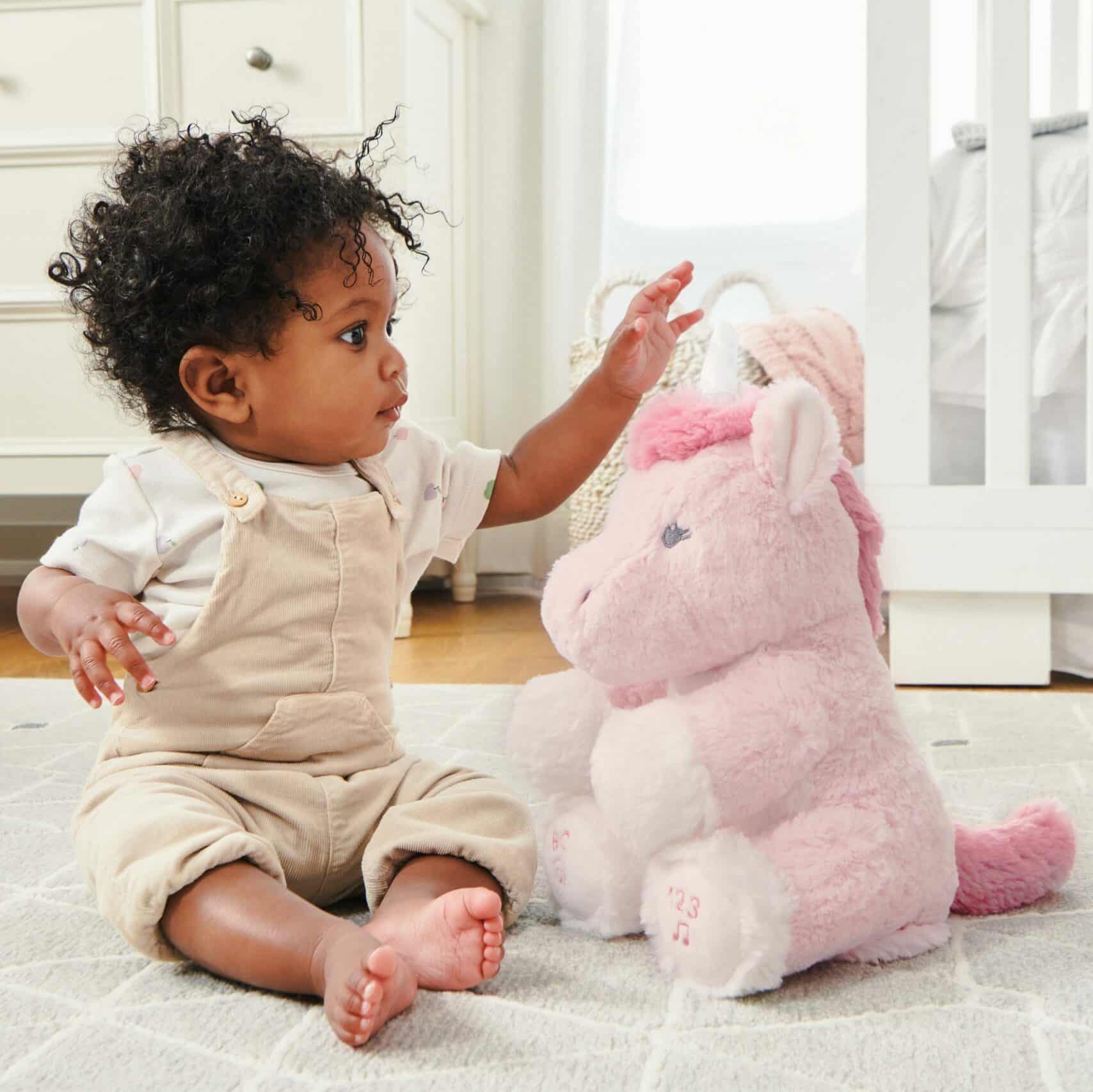 Baby playing with GUND unicorn stuffed animal