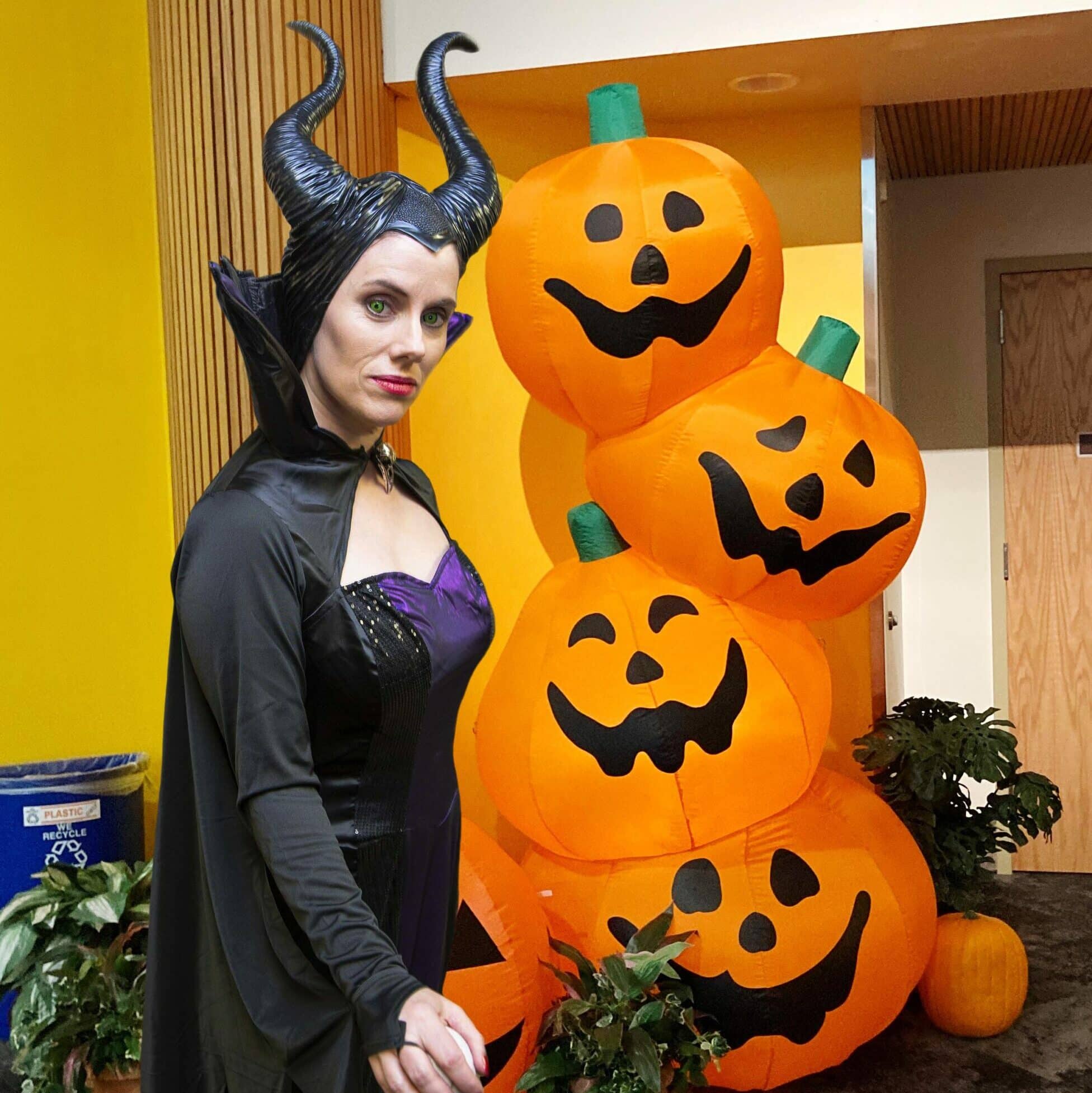 Maleficent standing by blown-up stack of jack-o-lanterns