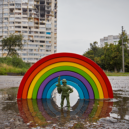 Toy Soldier standing in front of war-torn buildings in Ukraine