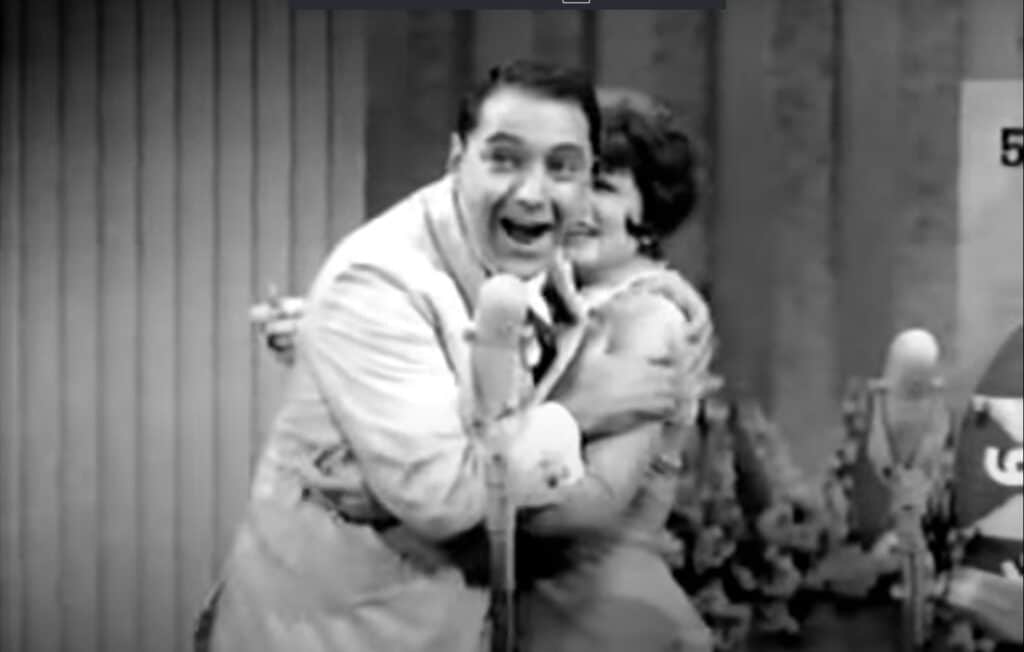 Hosts embracing on stage