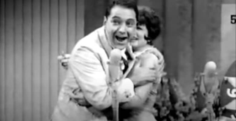 Hosts embracing on stage